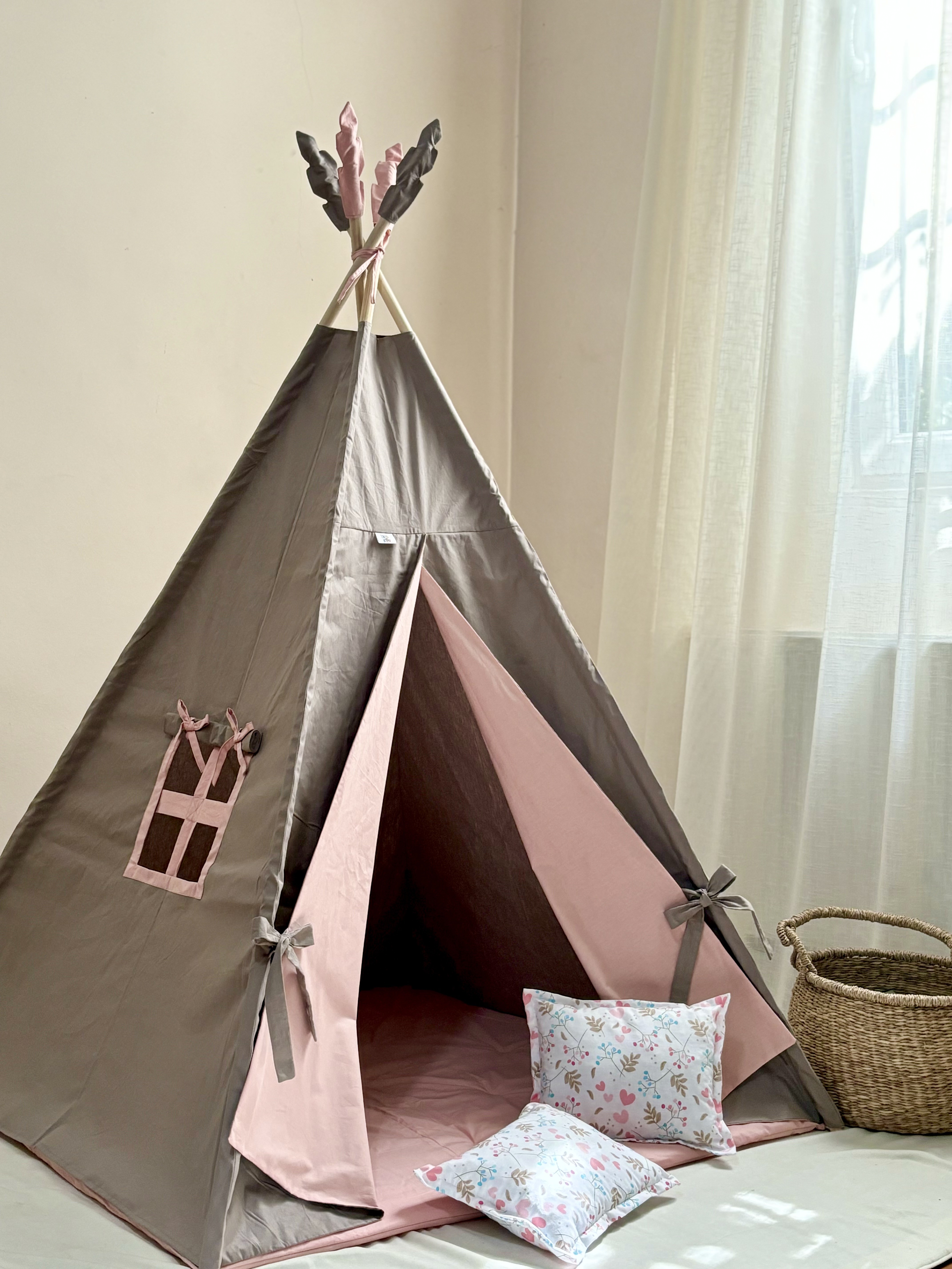 A brown tent with pink bedding and heart pillows