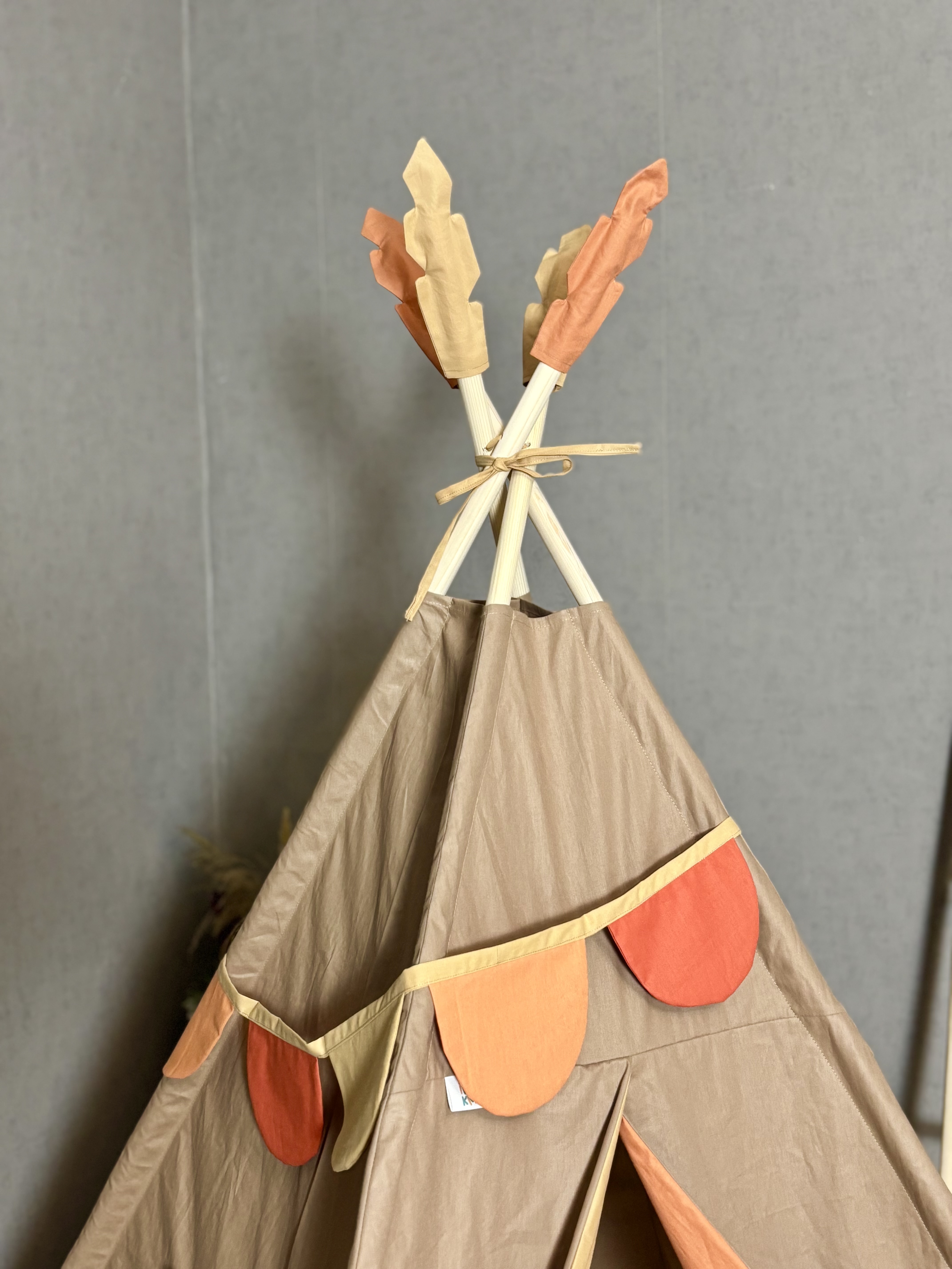 Light brown tent with a colorful entrance