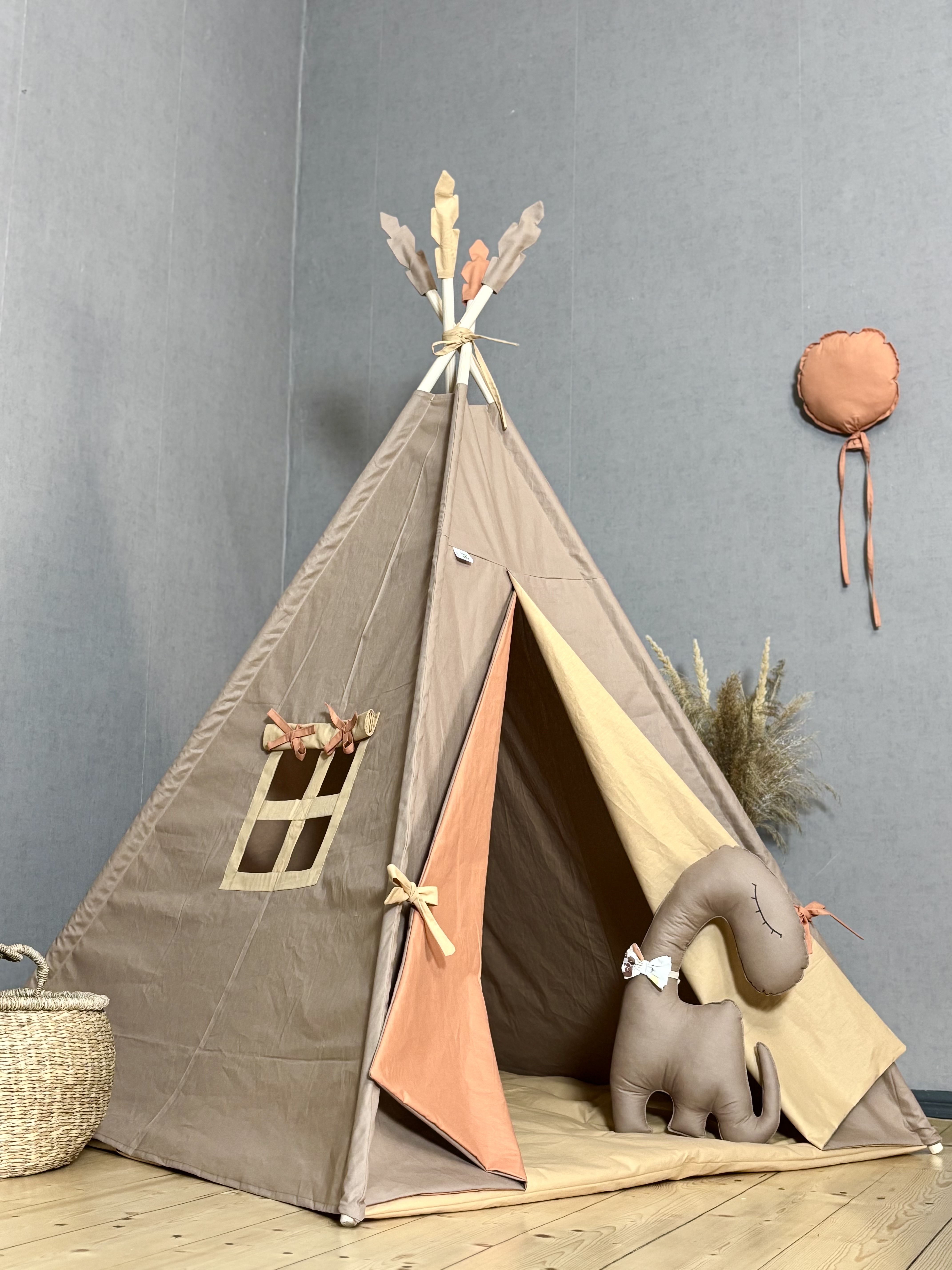 Light brown tent with toy dino and hanging balloon