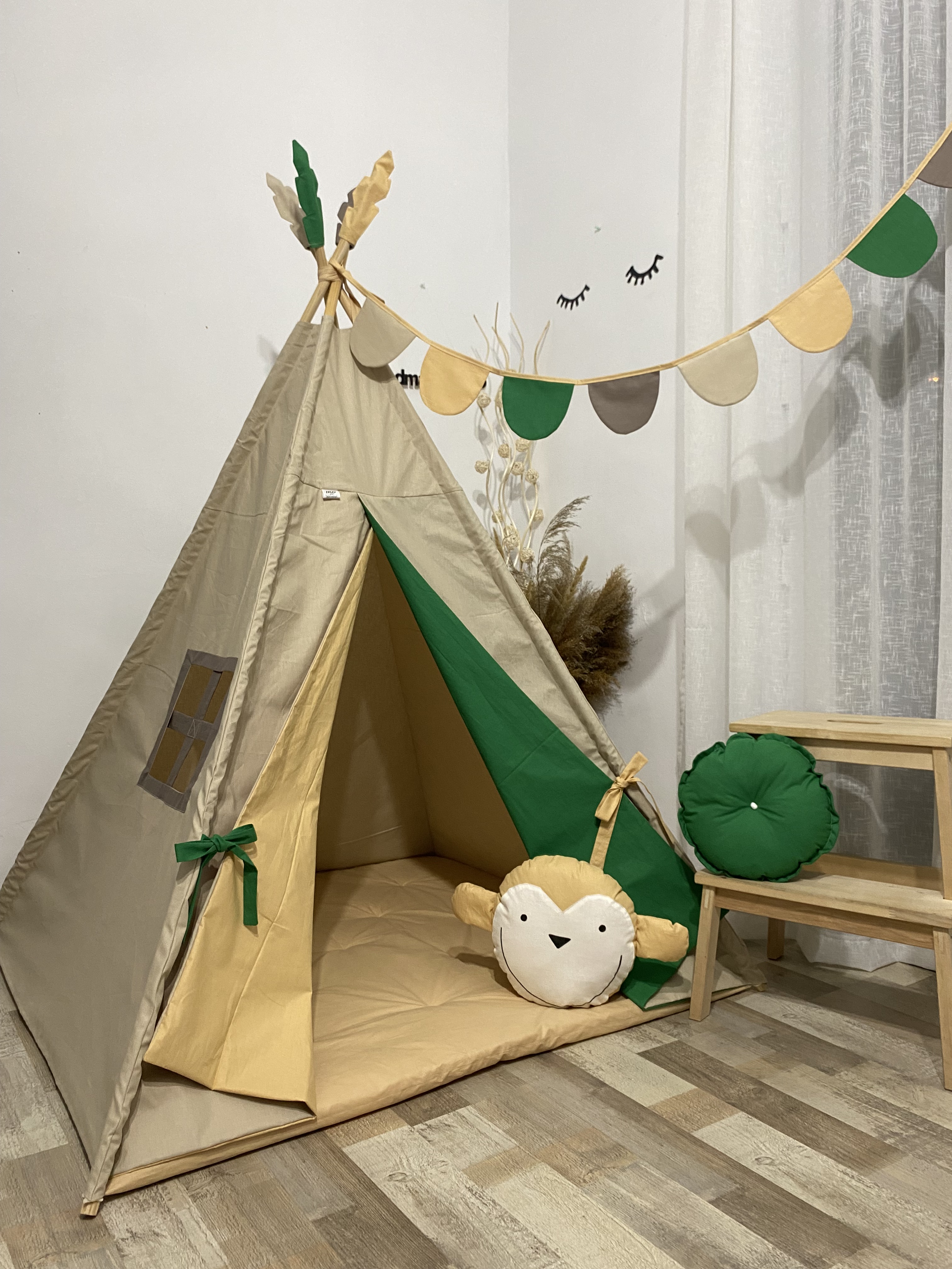 Kds' tent with colorful skirts and a pillow with a monkey, pillow with monkey and hanging flags