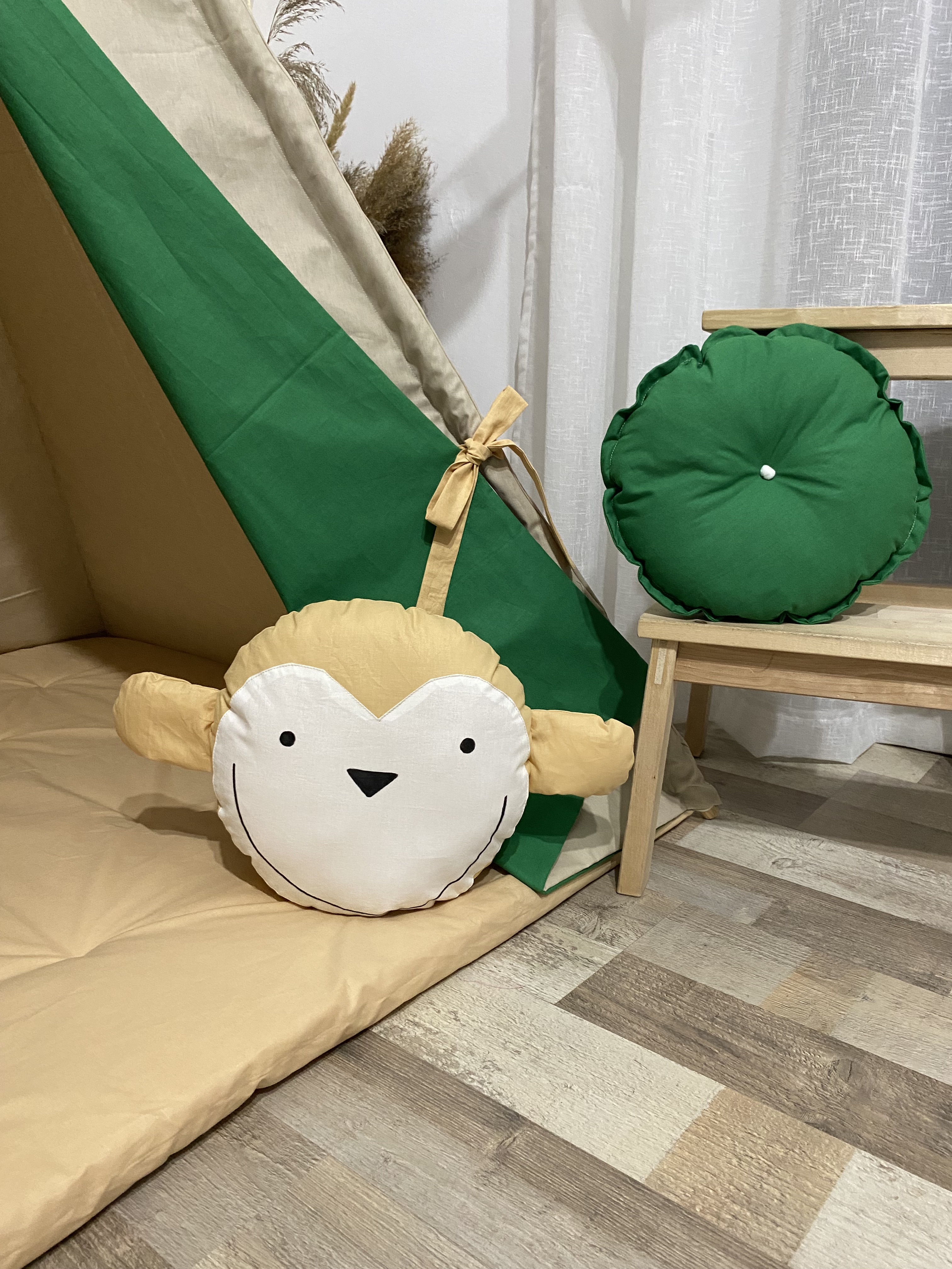 Kds' tent with colorful skirts and a pillow with a monkey, pillow with monkey and hanging flags